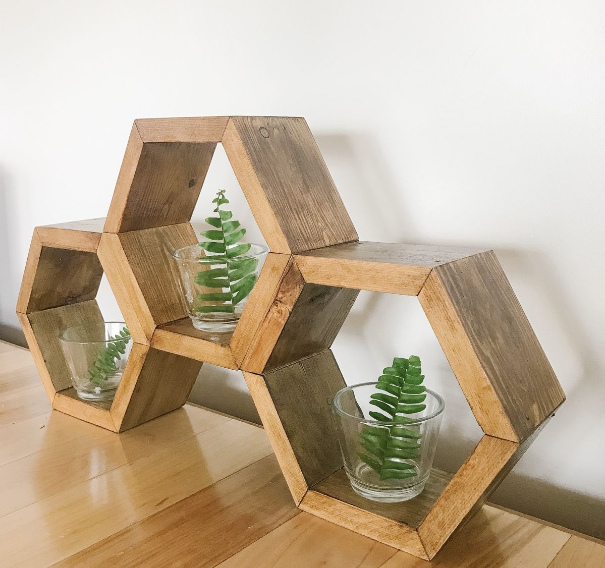Rustic hexagonal wood wall shelves styled with flowers and art piece