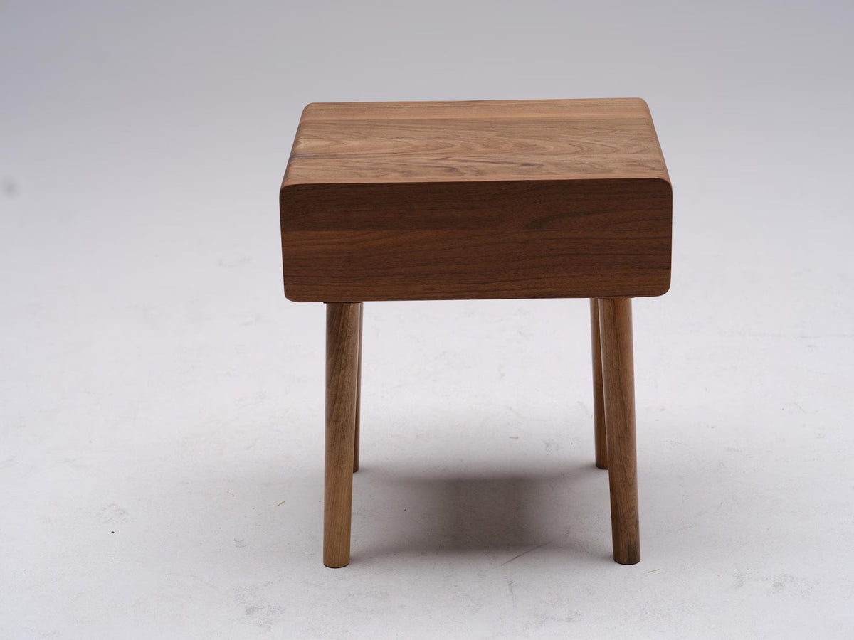 Walnut nightstand with integrated drawer shown from angle view