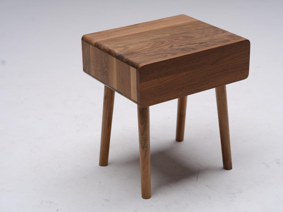 Solid walnut compact nightstand with round tapered legs front view